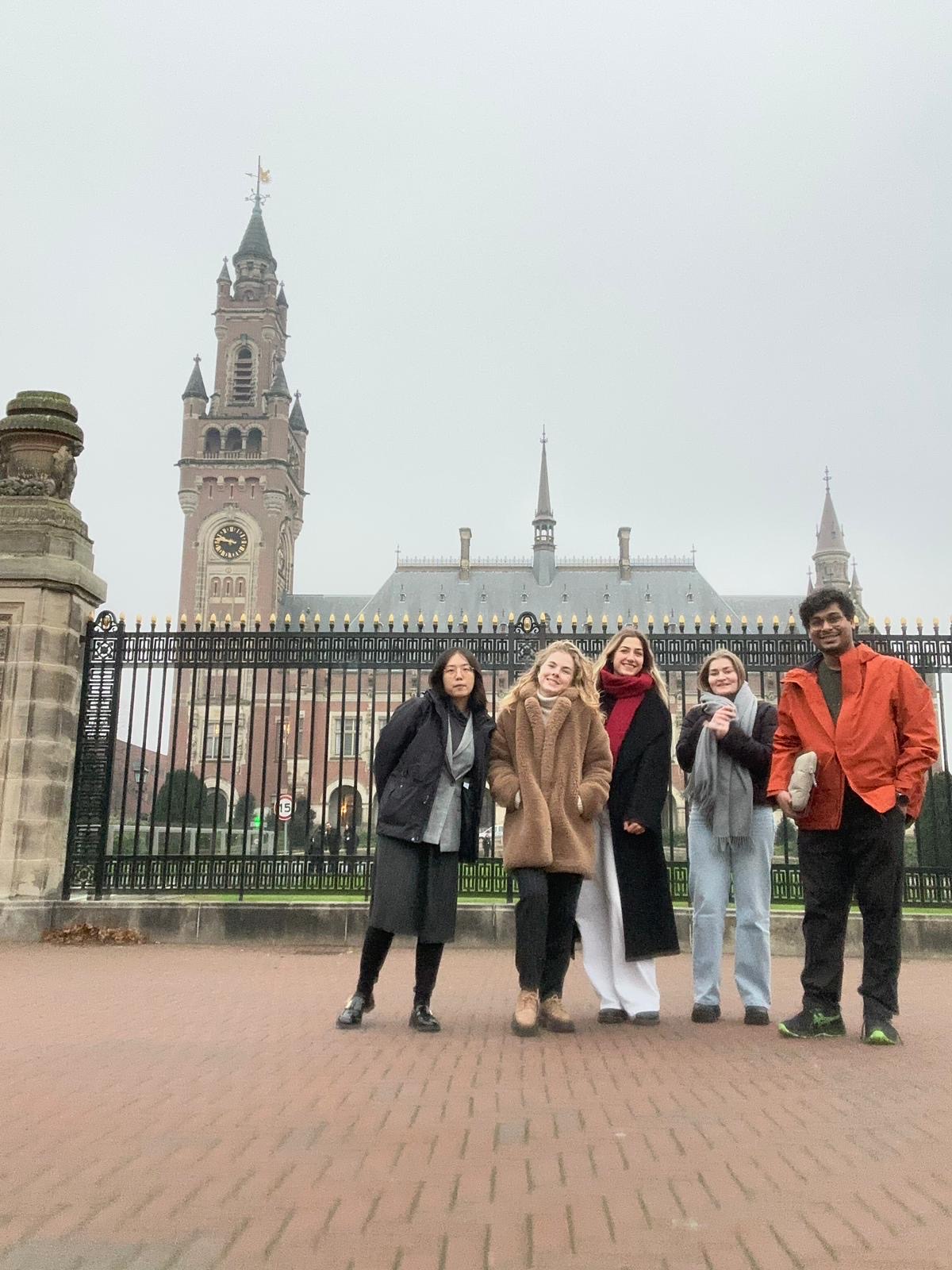 Five people in front of the Peace Palace in The Hague on an overcast day