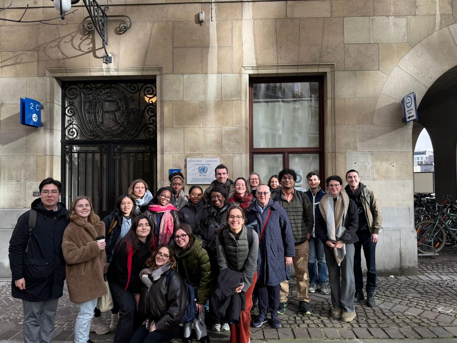 Student group in front of the UN Regional Information Centre building with a stone facade and iron gate